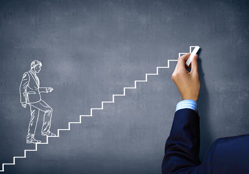 Close up of human hand drawing career ladder with chalk Close up of human hand drawing career ladder with chalk